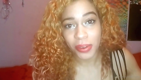 Ebony woman fucks herself with a vibrator on a sofa